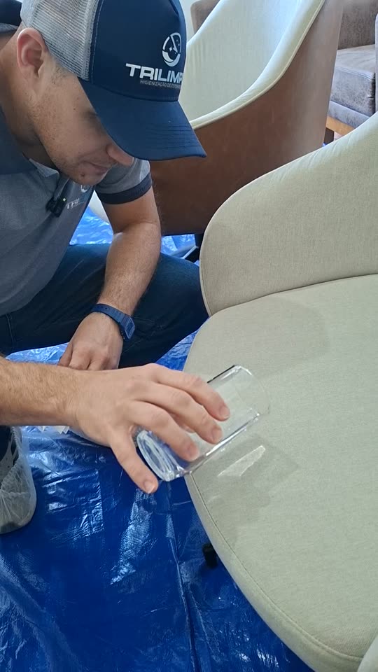Profissional da TRILIMPO fazendo um teste com água sobre uma poltrona