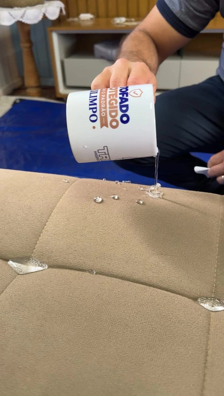 Profissional derramando água de uma caneca sobre o sofá